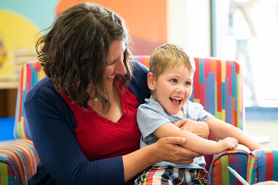 A woman and child laughing in a children's long-term support program.